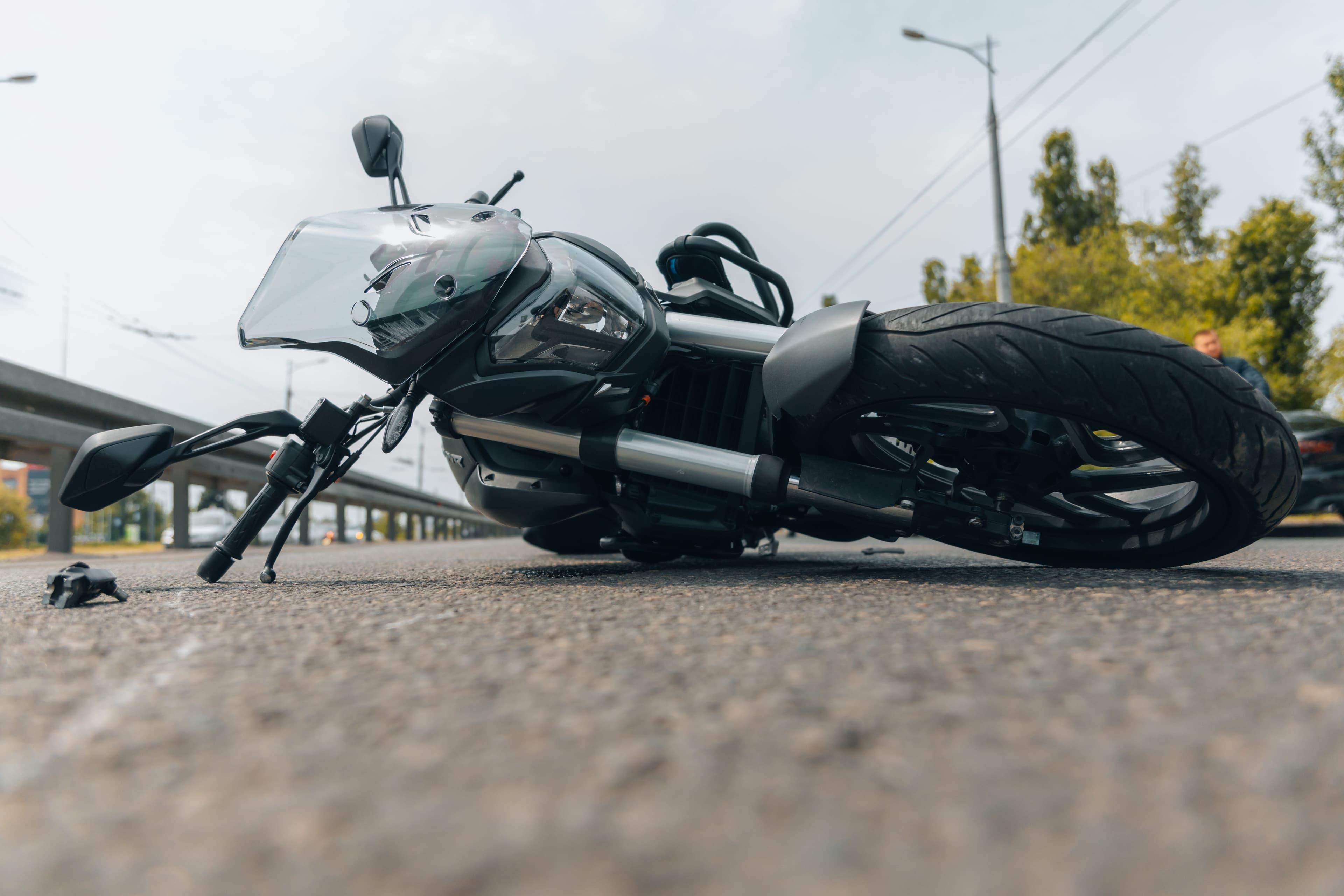 a motorcycle lays on its side in the road after an accident