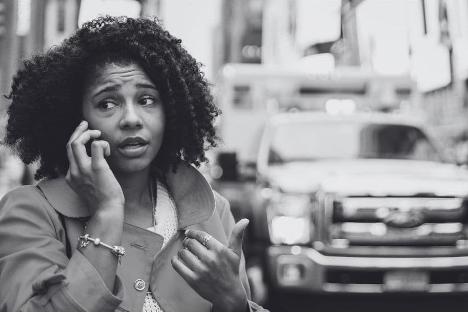 Woman on the phone in front of an ambulance