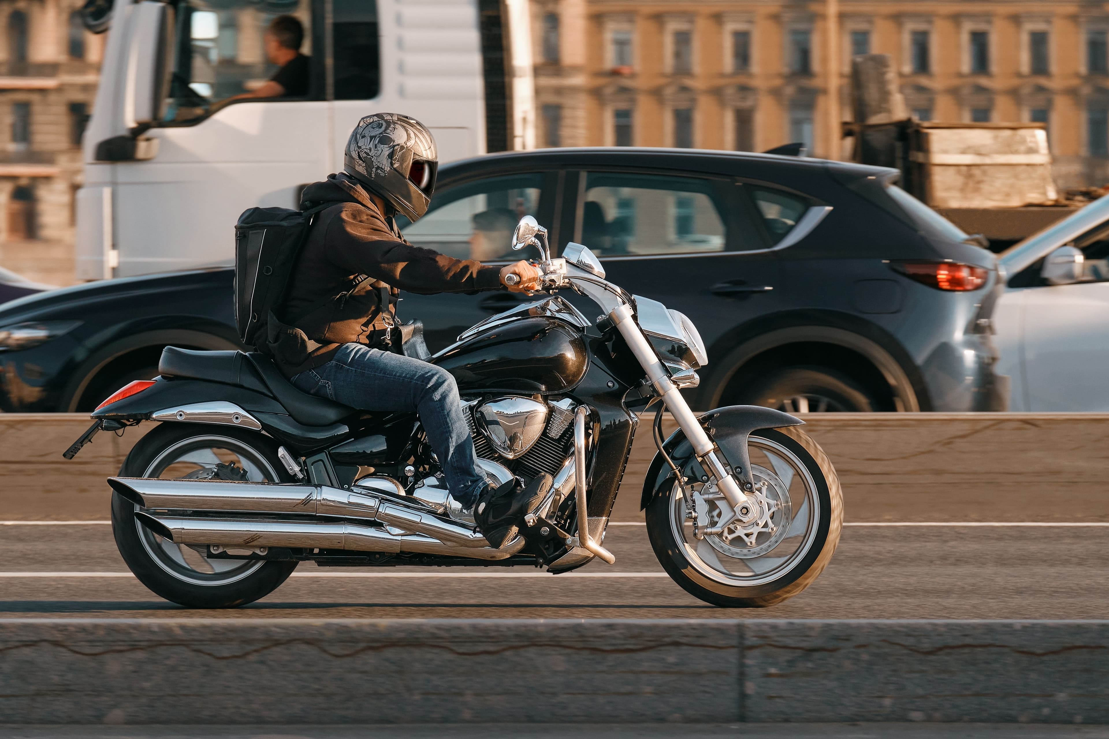 side view image of a man riding a motorcycle on a city highway